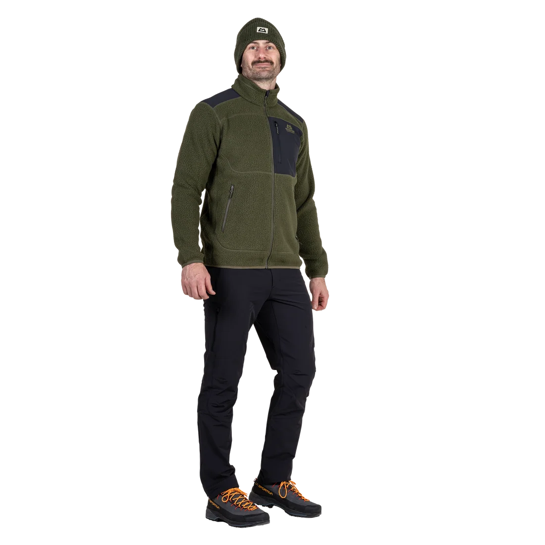 A man modeling an olive green fleece jacket with dark navy shoulder and chest panels, paired with black pants and black hiking boots with orange laces, against a plain white background. Mountain Equipment Men's Highpile Jacket Buckthorn / Black